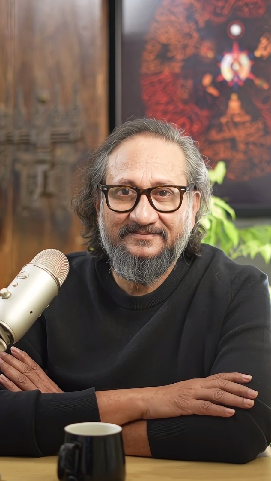 Nirmann Sir in conversation, seated at a microphone
